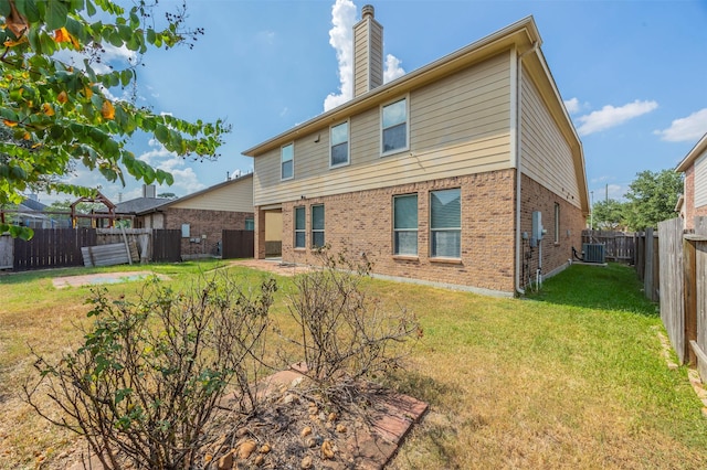 back of house with central AC unit and a lawn