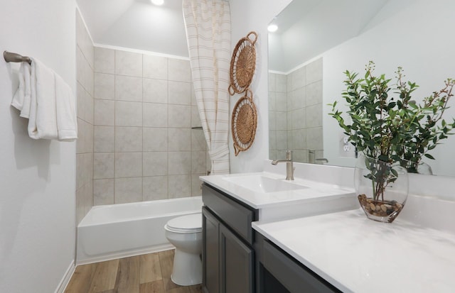 full bathroom with hardwood / wood-style floors, vanity, toilet, and tiled shower / bath combo