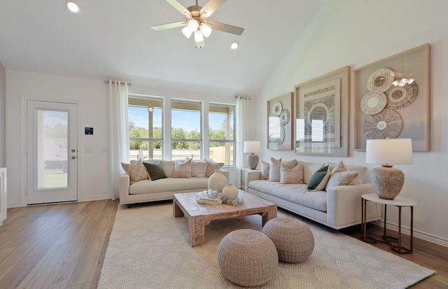 living room featuring light wood-type flooring, high vaulted ceiling, and ceiling fan