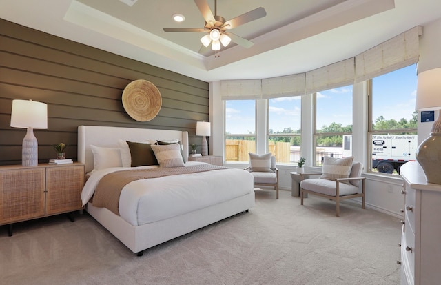 bedroom featuring ceiling fan, carpet floors, and a tray ceiling