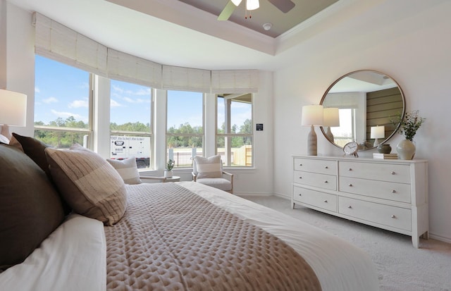 bedroom featuring a raised ceiling, ceiling fan, crown molding, and light carpet