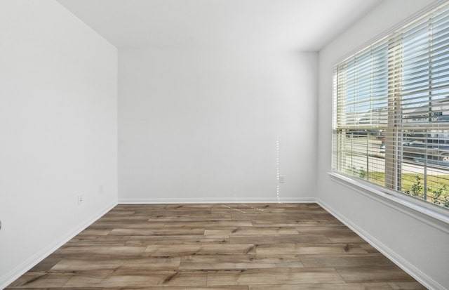 unfurnished room featuring light wood-type flooring and baseboards