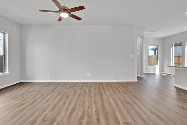 spare room with light hardwood / wood-style flooring, plenty of natural light, and ceiling fan