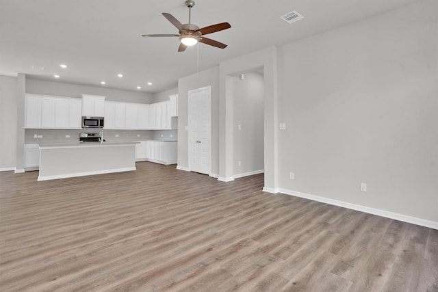 unfurnished living room featuring ceiling fan and light hardwood / wood-style floors