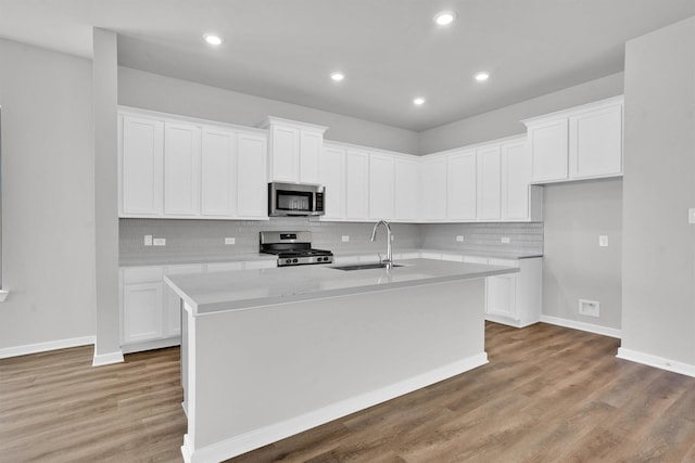 kitchen featuring white cabinetry, a center island with sink, stainless steel appliances, and sink