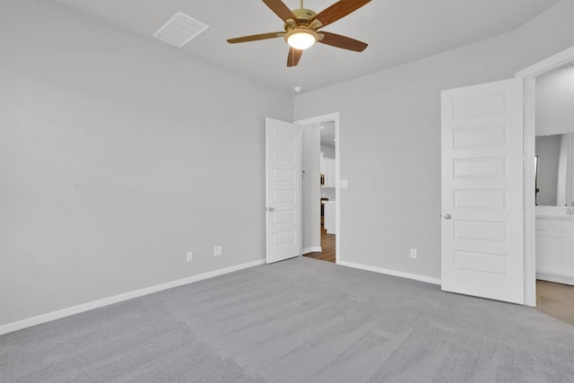 unfurnished bedroom with ceiling fan, light carpet, and ensuite bath