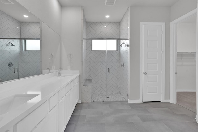 bathroom with tile patterned flooring, plenty of natural light, vanity, and walk in shower