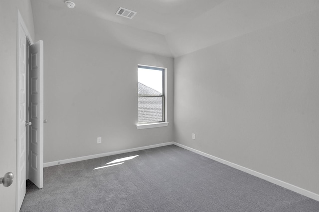 carpeted empty room with lofted ceiling