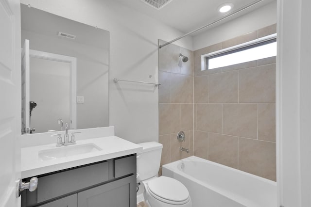 full bathroom featuring toilet, vanity, and tiled shower / bath combo