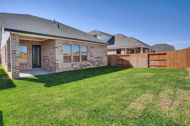 back of house with a patio area and a yard