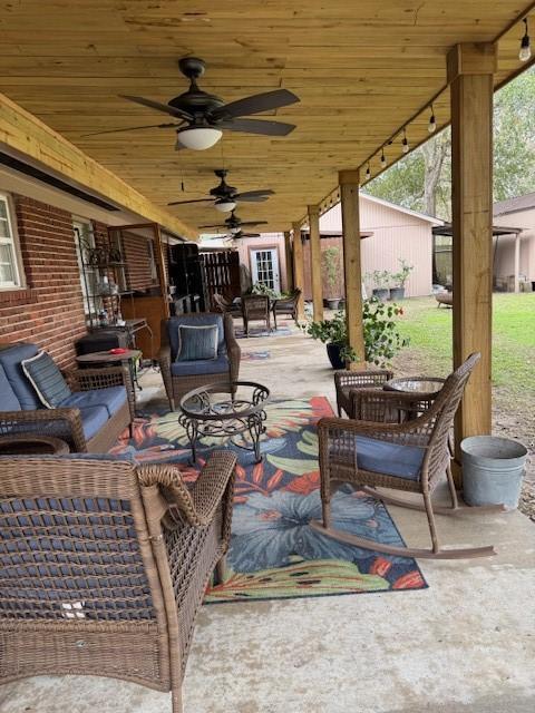 view of patio with an outdoor living space and ceiling fan