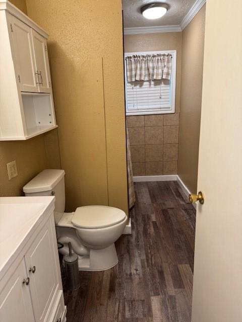 bathroom featuring crown molding, hardwood / wood-style floors, vanity, and toilet