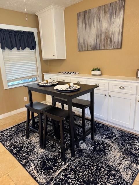 tiled dining space featuring a textured ceiling