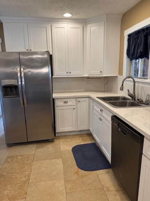 kitchen with sink, dishwasher, light stone counters, stainless steel fridge, and white cabinets