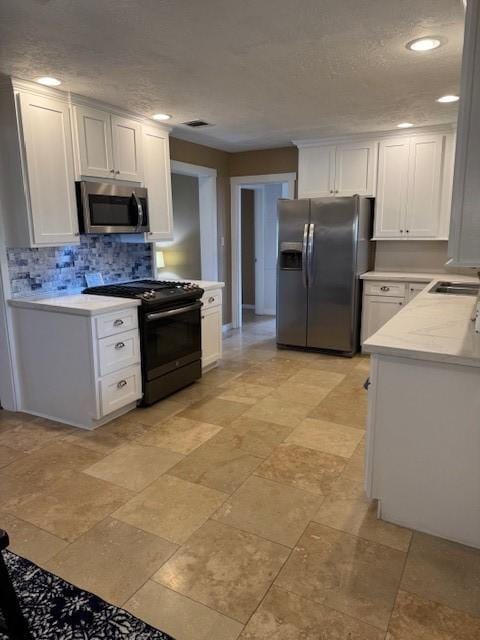 kitchen with white cabinets, backsplash, stainless steel appliances, and sink