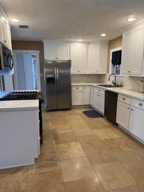 kitchen with black appliances, white cabinetry, sink, and a textured ceiling