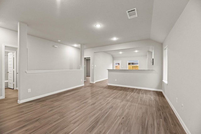 unfurnished living room featuring lofted ceiling and dark wood-type flooring