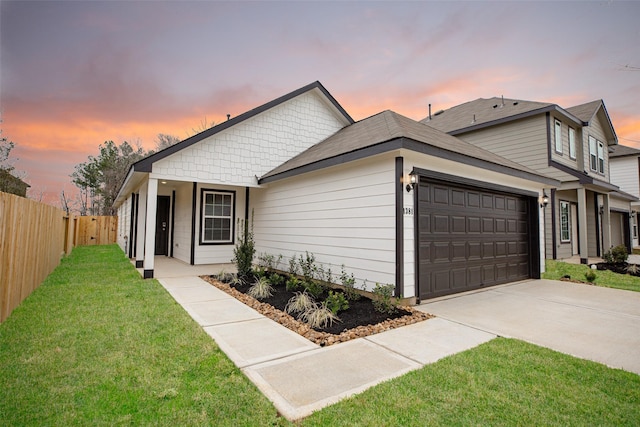 view of front of property with a garage and a lawn