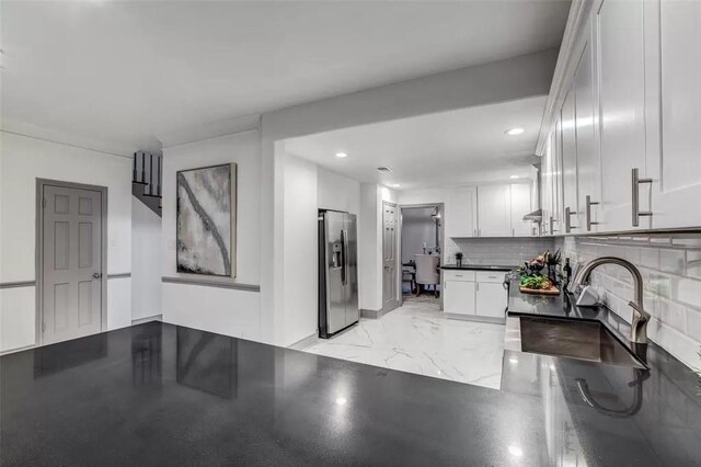 kitchen with white cabinets, backsplash, stainless steel fridge with ice dispenser, and sink