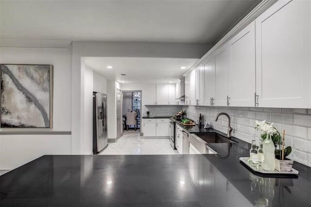 kitchen featuring stainless steel refrigerator with ice dispenser, backsplash, white cabinetry, and sink