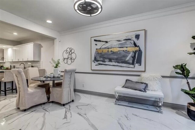 dining space featuring sink and crown molding