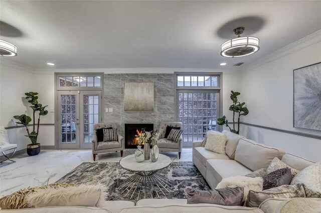 living room featuring french doors, ornamental molding, and a tiled fireplace