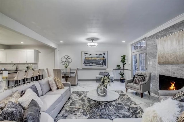 living room featuring a high end fireplace and crown molding