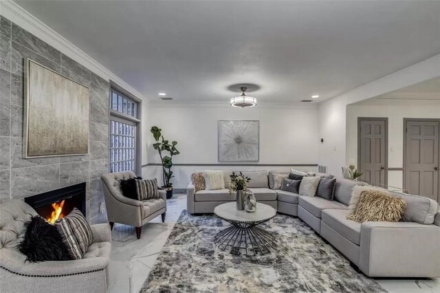 living room with crown molding and a tile fireplace