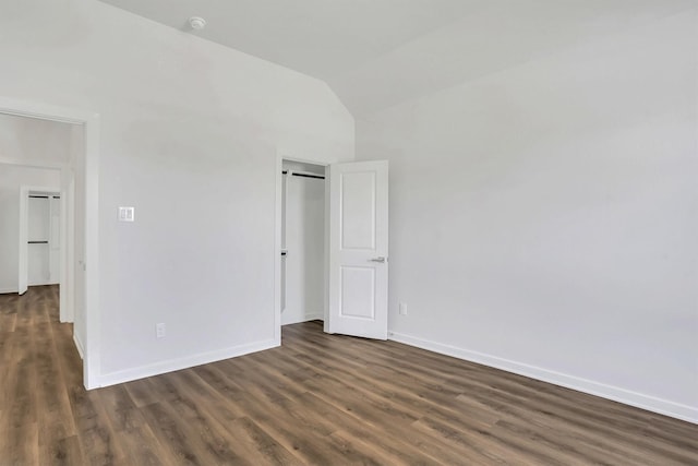 unfurnished bedroom with dark hardwood / wood-style flooring and lofted ceiling