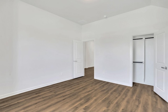 unfurnished bedroom with dark wood-type flooring and a closet