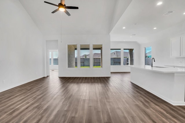 unfurnished living room featuring ceiling fan, dark hardwood / wood-style flooring, and sink