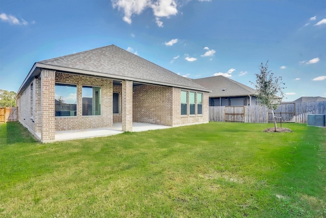 rear view of property with a lawn and a patio area