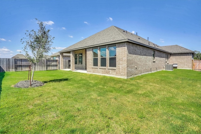 rear view of property with a lawn and central AC unit