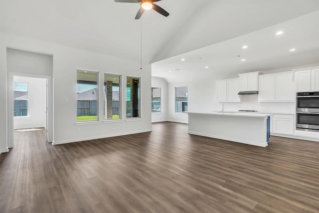 unfurnished living room with ceiling fan, sink, high vaulted ceiling, and dark wood-type flooring