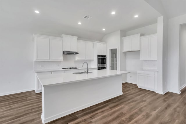 kitchen featuring a center island with sink, white cabinets, sink, dark hardwood / wood-style floors, and gas cooktop