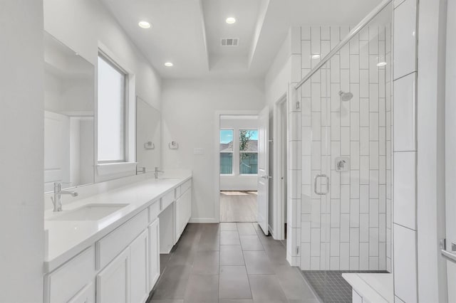 bathroom with tile patterned flooring, vanity, and walk in shower