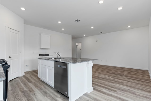 kitchen featuring dishwasher, a center island with sink, white cabinets, and dark stone counters