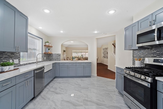 kitchen with decorative backsplash, appliances with stainless steel finishes, and sink