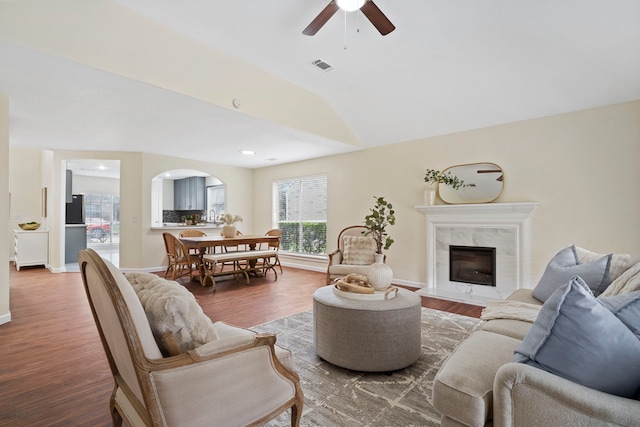 living room featuring a high end fireplace, wood-type flooring, ceiling fan, and sink