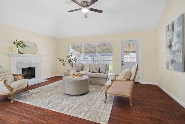 living room featuring vaulted ceiling, dark wood-type flooring, and a premium fireplace