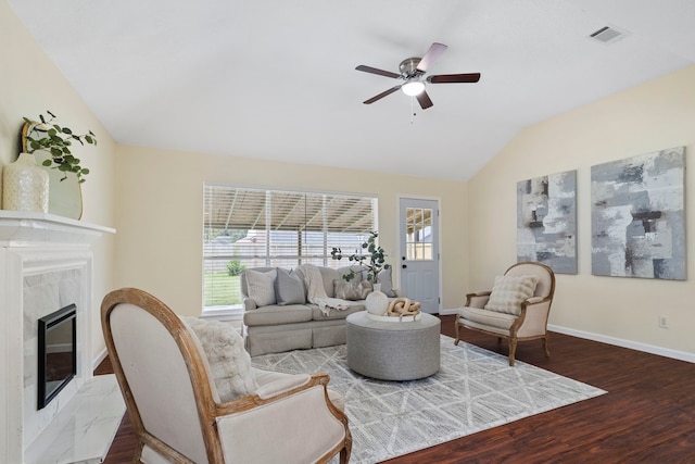 living room featuring hardwood / wood-style floors, ceiling fan, a fireplace, and vaulted ceiling