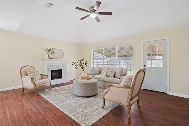 living room featuring a high end fireplace, ceiling fan, and dark wood-type flooring