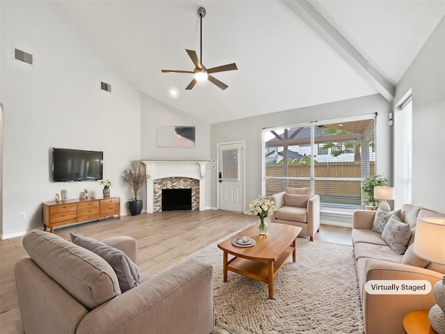 living room featuring a stone fireplace, ceiling fan, light hardwood / wood-style flooring, and high vaulted ceiling