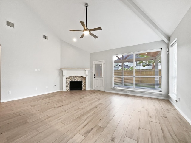 unfurnished living room featuring ceiling fan, a stone fireplace, high vaulted ceiling, and light hardwood / wood-style flooring