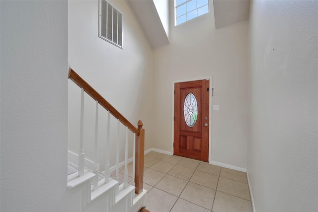 tiled foyer featuring a high ceiling