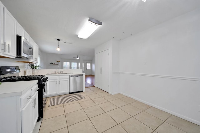 kitchen featuring white cabinets, ceiling fan, light tile patterned flooring, and stainless steel appliances