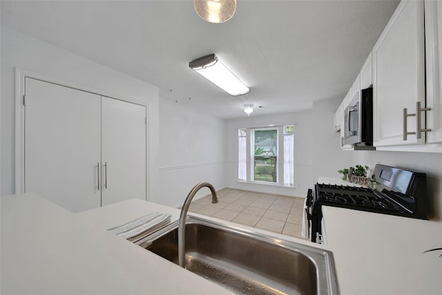 kitchen with sink, white cabinetry, and black gas range oven