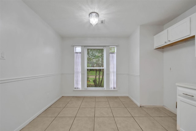 unfurnished dining area featuring light tile patterned floors