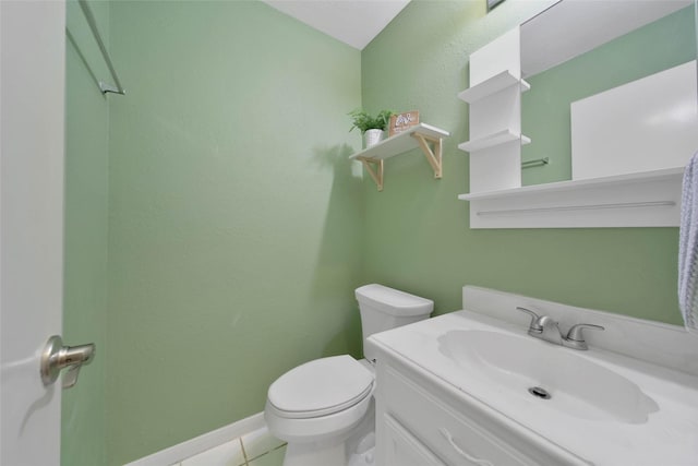 bathroom with tile patterned flooring, vanity, and toilet