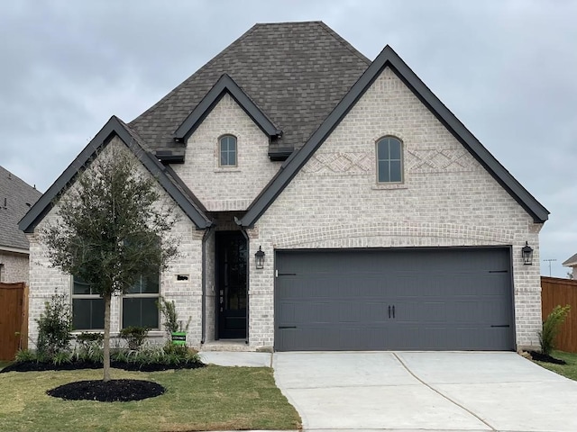 french country style house featuring a front yard and a garage